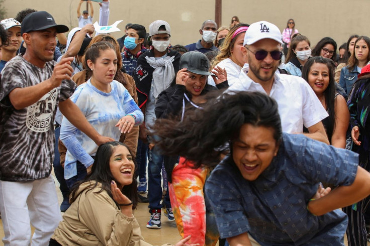 Central American migrants dance during an event named "Virtual Reality Baroque Opera" as they await the result of their asylum request to U.S, in Tijuana, Mexico May 28, 2022.