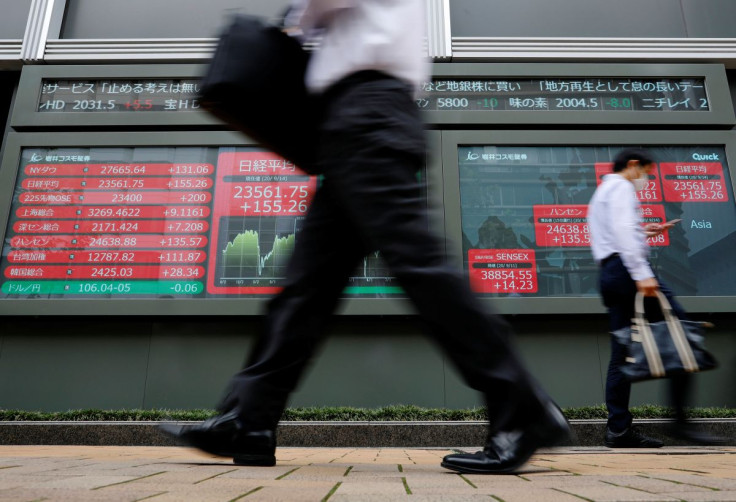 Passersby walk past an electronic board showing Japan's Nikkei average, in Tokyo, Japan September 14, 2020.  