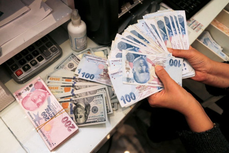 A money changer holds Turkish lira banknotes at a currency exchange office in Ankara, Turkey October 12, 2021. 