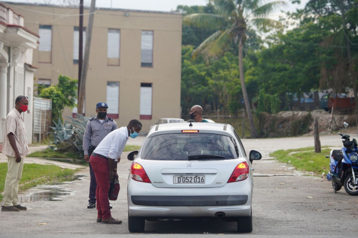 A police officer stops a car with diplomats from heading to the court house where Cuban leader of a dissident art collective Otero Alcantara and rapper Maykel Castillo stand trial for public disorder and defamation of public institutions and national symb