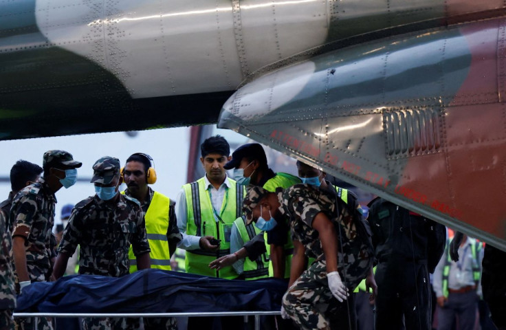 Member of Nepal Army carries the body of a victim of the Tara Air passenger plane, that crashed with 22 people on board while on its way to Jomsom, from the helicopter at the airport in Kathmandu, Nepal May 30, 2022. 