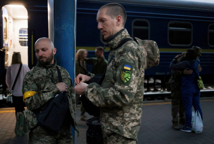 Territorial Defence members Oleksandr Zhygan, 37, and partner Antonina Romanova, 37, prepare to board a train to the frontline, as Russia's attack on Ukraine continues, at a train station in Kyiv, Ukraine May 25, 2022. Picture taken May 25, 2022. 