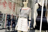 People stand next to the window of a fashion boutique in a shopping district in Tokyo, Japan, May 30, 2016. 
