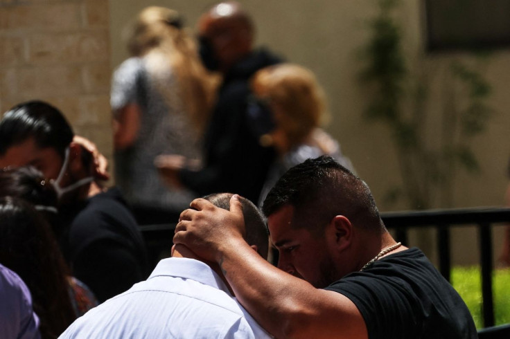 People comfort each other outside the Sacred Heart Catholic Church after attending the funeral service of Amerie Jo Garza, one of the victims of the Robb Elementary school mass shooting that resulted in the deaths of 19 children and two teachers, in Uvald