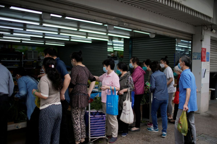 People wearing face masks line up at a food store, after the lockdown placed to curb the coronavirus disease (COVID-19) outbreak was lifted in Shanghai, China June 1, 2022.