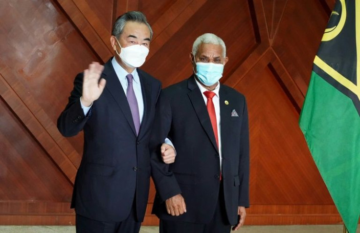 Chinese Foreign Minister Wang Yi (L) has been inking a series of agreements on each of his stops through the Pacific
