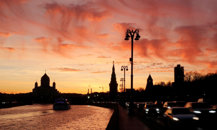 Vehicles travel along the embankment of the Moskva River during sunset, as the Cathedral of Christ the Saviour is seen in the background, in Moscow, Russia October 25, 2021. 