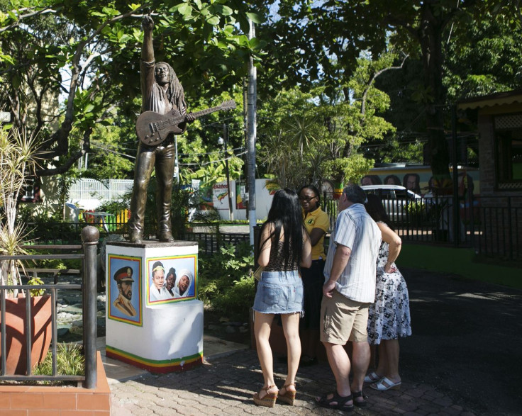 Tourists view a statue of Bob Marley outside the Bob Marley Museum in Kingston December 13, 2013.
