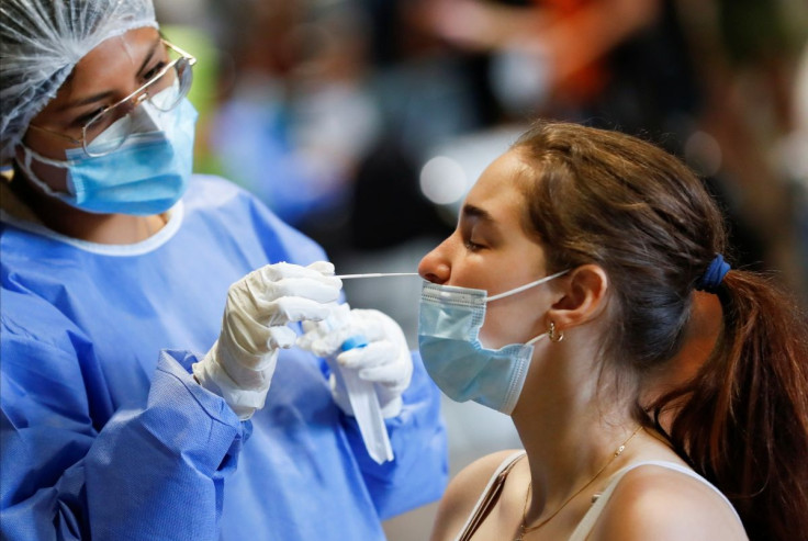 A healthcare worker takes a swab sample from a woman to be tested for the coronavirus disease (COVID-19), at La Rural, in Buenos Aires, Argentina December 23, 2021. Picture taken December 23, 2021. 