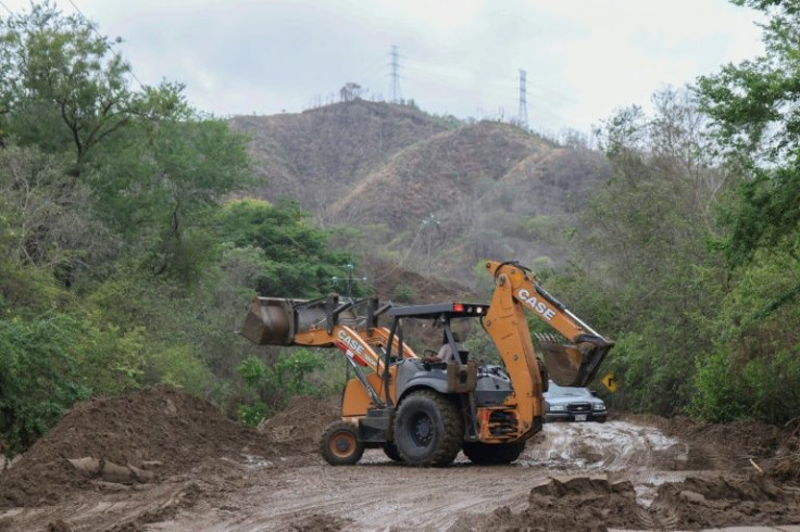 A backhoe works to clear a road in southern Mexico cut off by Hurricane Agatha