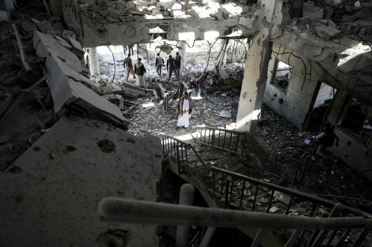 Security guards and journalists inspect the site of Saudi-led air strike on a telecommunication station in Sanaa, Yemen February 14, 2022. 