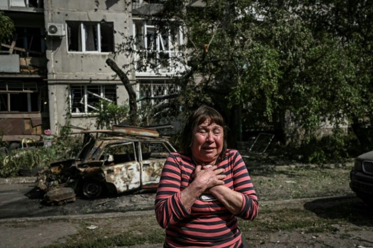 A woman reacts outside a damaged appartment building after a strike in the city of Slovyansk on May 31, 2022