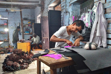 Ashok Kumar, a worker, cuts synthetic leather to make shoes at the Vansh Foot Fashion, a small shoe making factory, in Agra, India, May 30, 2022. 