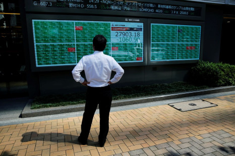 A man watches an electric board showing Nikkei index outside a brokerage at a business district in Tokyo, Japan, June 21, 2021.   