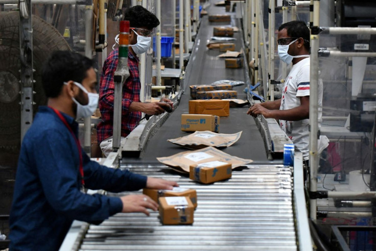 Workers at Flipkart, a leading e-commerce firm in India, sort packets on a conveyor belt inside its fulfilment centre on the outskirts of Bengaluru, India, September 23, 2021.