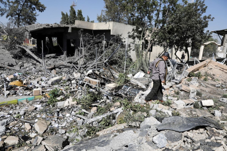 An airport staffer walks through the rubble of a building destroyed by Saudi-led air strikes at Sanaa Airport in Sanaa, Yemen December 21, 2021.