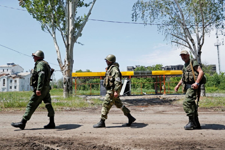 Service members of pro-Russian troops walk along a street during Ukraine-Russia conflict in the town of Popasna in the Luhansk Region, Ukraine June 2, 2022. 