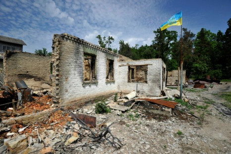 A Ukrainian flag waves over a house destroyed by shelling in the village of Moshchun, Kyiv region, on June 2, 2022 on the 99th day of the Russian invasion of Ukraine