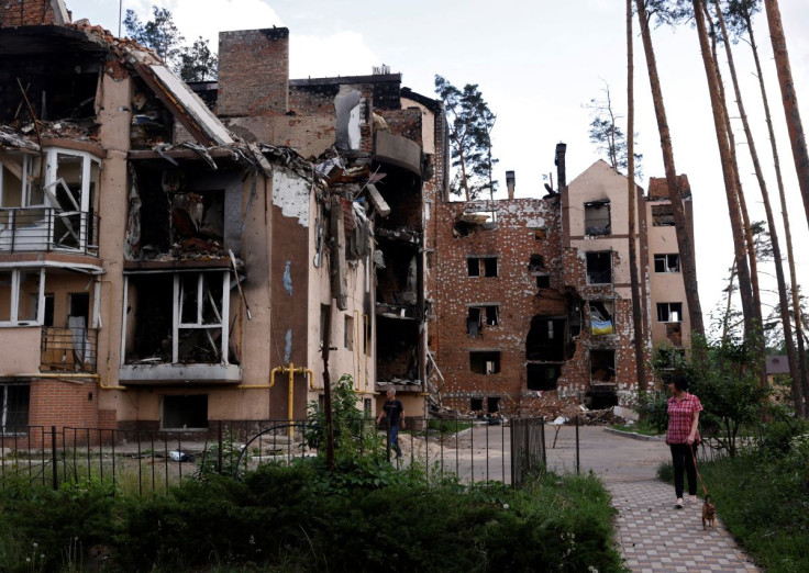 Resident Lyudmila, who lives in a destroyed apartment block, walks her dog near her home in Irpin, outside Kyiv, as Russia's attacks on Ukraine continues, June 2, 2022. 