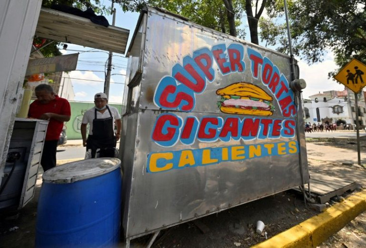 A view of a street food stand in Mexico City that still has its colorful sign advertising tortas, a type of sandwich