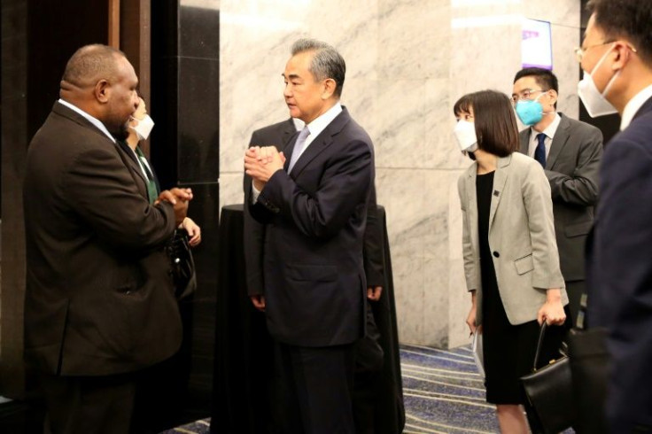 Chinese foreign minister Wang Yi (C) talks to Papua New Guinea's leader James Marape (L) in Port Moresby