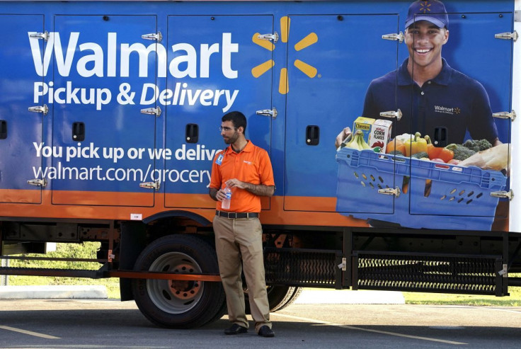 A Wal-Mart Pickup-Grocery employee waits next to a truck at a test store in Bentonville, Arkansas June 4, 2015.