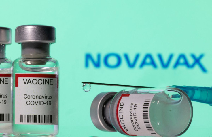 Vials labelled "VACCINE Coronavirus COVID-19" and a syringe are seen in front of a displayed Novavax logo in this illustration taken December 11, 2021. 