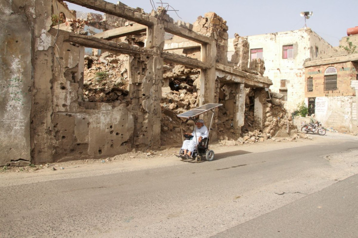 A man rides a wheelchair past a building damaged by war in Taiz, Yemen May 20, 2022. Picture taken May 20, 2022.