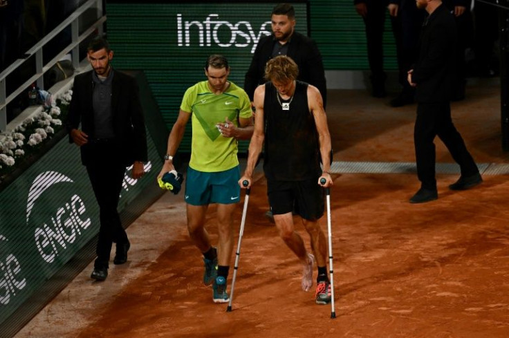 All over: Alexander Zverev walks with crutches back on to the court