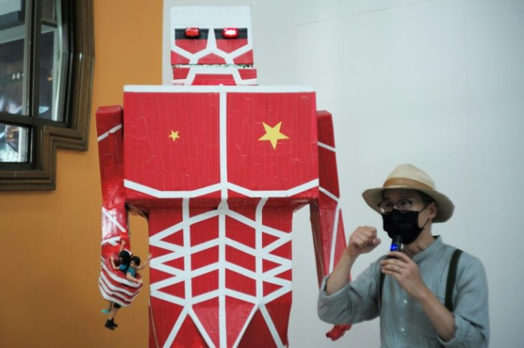 Kacey Wong, a political artist living in Taiwan, speaks beside his work entitled "Attack of the Red Giant" at the Cross-Border Art Exhibition in Taipei