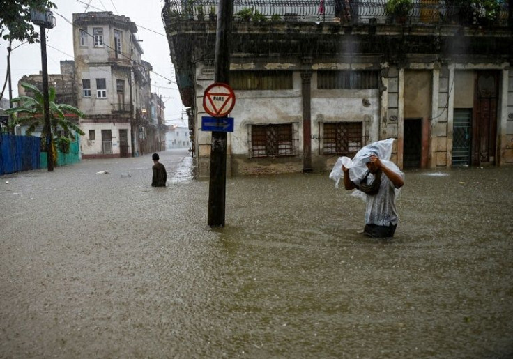 Men wade along a flooded street in Havana, on June 3, 2022