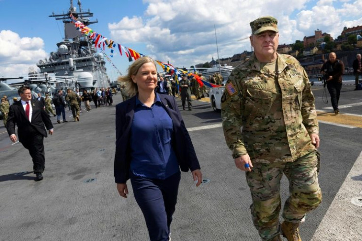 Swedish Prime Minister Magdalena Andersson (L) and top US general Mark Milley walk aboard the American amphibious warship USS Kearsarge in Stockholm, Sweden ahead of the Baltic Operations 'Baltops 22' exercise
