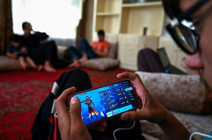Afghan boys play PUBG on mobile phones in Kabul