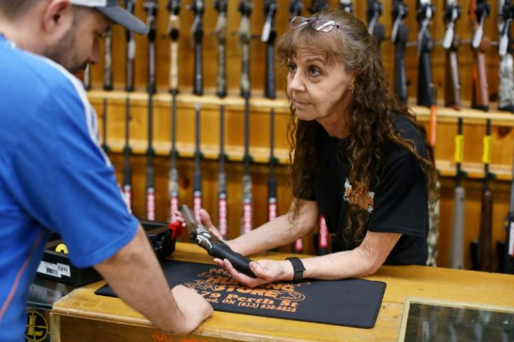 Jen Lavigne (R), co-owner of That Hunting Store in Ottawa, Canada, shows a customer a Ruger GP100 Magnum 357