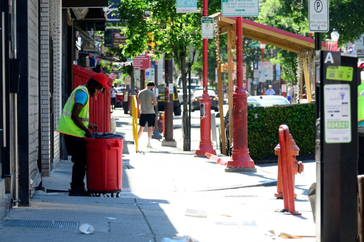 A man from cleaning crew sweeps the street after a deadly mass shooting, on South Street in Philadelphia, Pennsylvania, U.S., June 5, 2022. 