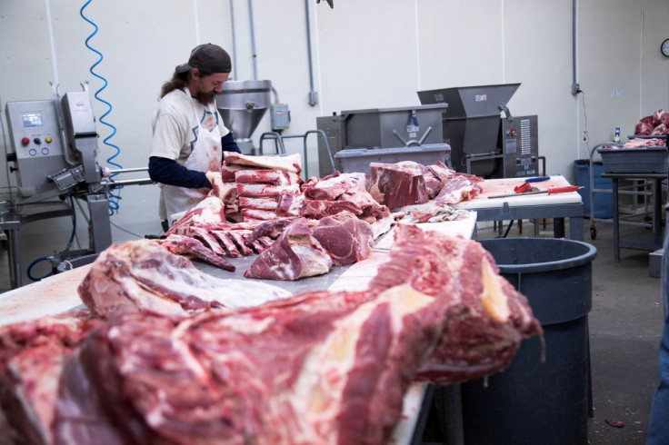 Employee cuts fresh beef meat into large pieces at a meat processing plant in Corydon, Indiana U.S. January 31, 2022.