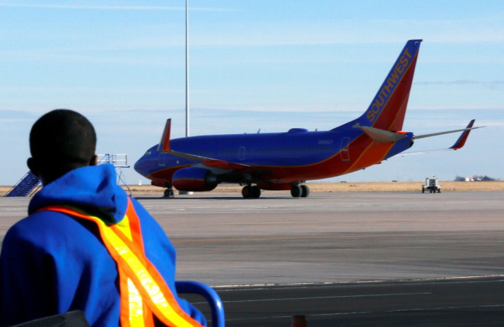 A luggage handler watches a departing Southwest Airlines Boeing 737-700 jet at Denver International Airport in Denver January 22, 2014.