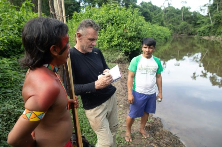 In this November 16, 2019 photo, British journalist Dom Phillips, who went missing while researching a book in the Brazilian Amazon's Javari Valley with respected indigenous expert Bruno Pereira, talks to two indigenous men in Brazil's Roraima state