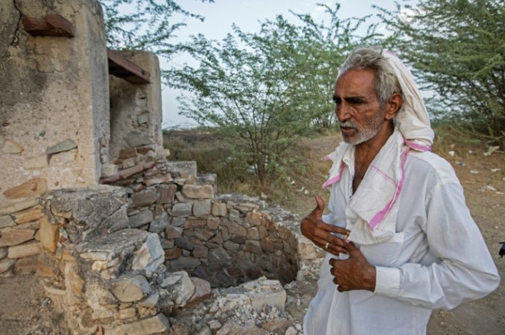 Sardar Meena, the three brides' father, stands next to the well where his daughters and two grandchildren were found dead