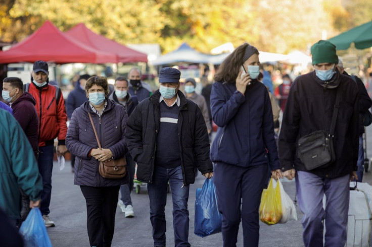 People wearing protective masks walk in a market, following the introduction of new restrictions imposed by the government after a surge in coronavirus disease (COVID-19) cases in Bucharest, Romania, October 26, 2021. Inquam Photos/George Calin via REUTER