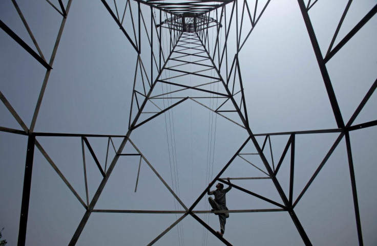 A worker of Peshawar Electric Supply Company (PESCO) climbs up a high-voltage pylon in Peshawar, Pakistan August 7, 2017.