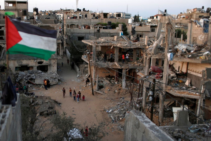 A Palestinian flag flies as the ruins of houses, which were destroyed by Israeli air strikes during the Israeli-Palestinian fighting, are seen, in Gaza Strip, May 25, 2021.