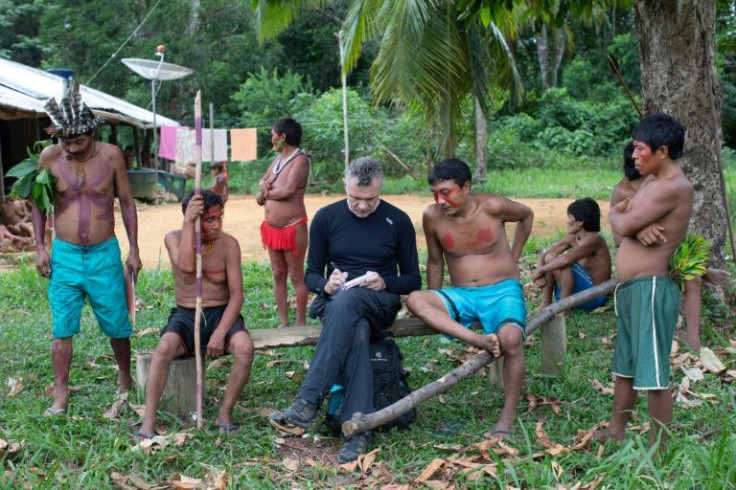 Veteran foreign correspondent Dom Phillips (C) takes notes as he talks with indigenous people in the Brazilian Amazon in 2019