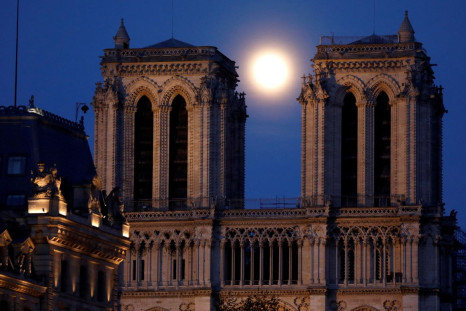 The pink supermoon rises between the two towers of Notre Dame Cathedral, which was damaged in a devastating fire almost one year ago, ahead of Easter celebrations to be held under lockdown imposed to slow the spread of the coronavirus disease (COVID-19), 