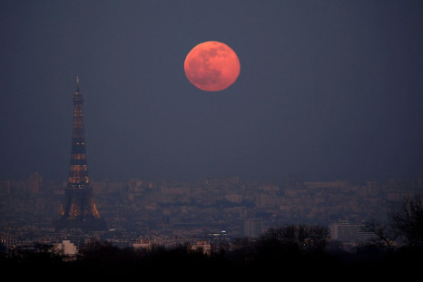 The moon rises behind the Eiffel Tower during a nationwide curfew, from 6 p.m to 6 a.m, due to tighter measures against the spread of the coronavirus disease (COVID-19) in Paris, France, February 27, 2021.   