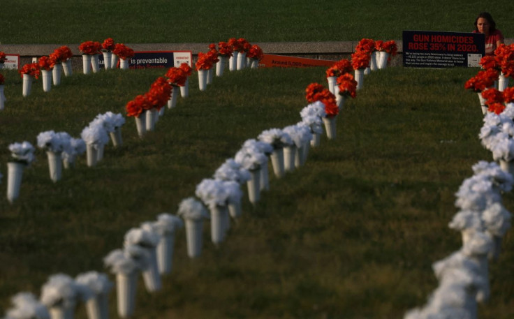 A pedestrian reads a sign at a memorial honoring 45,000 lives lost due to gun violence in 2020 seen on the National Mall near the Washington Monument in Washington, U.S., June 7, 2022.