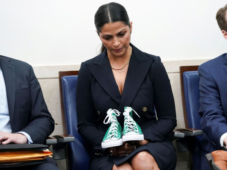 Camila Alves McConaughey, a model, designer and the wife of actor Matthew McConaughey, holds a pair of sneakers used to identify one of the student victims as her husband speaks to reporters about the recent mass shooting at an elementary school in his ho