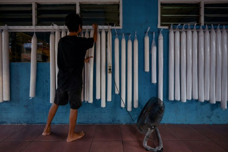 An employee prepares raw tempe, a traditional Indonesian food made from fermented soybeans, before being fried into chips