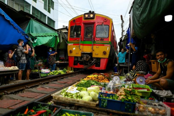 Six times a day at the market, vendors calmly move their woven baskets of goods away from the tracks to make way for the passing train