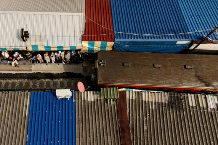 Six times a day, the train narrowly skirts the stalls of the Mae Klong railway market